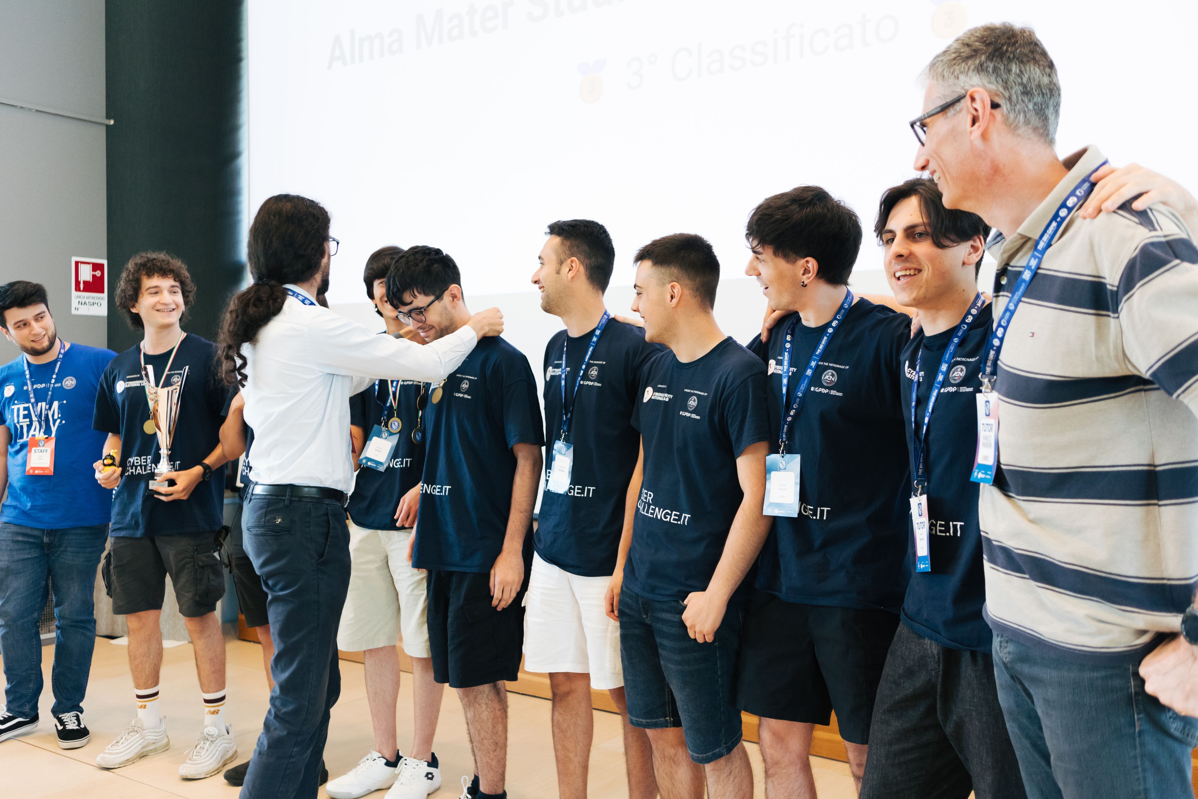 Foto del della consegna di una medaglia da parte di Gaspare Ferraro ad un membro del team unibo